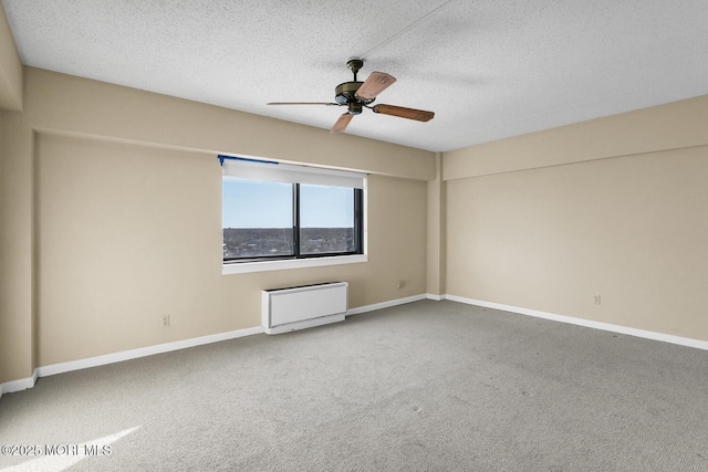 empty room featuring carpet flooring, ceiling fan, a textured ceiling, and baseboards