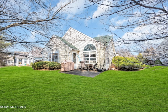 rear view of property with a patio and a lawn