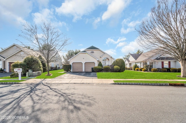 view of front of house featuring a front yard, concrete driveway, and an attached garage