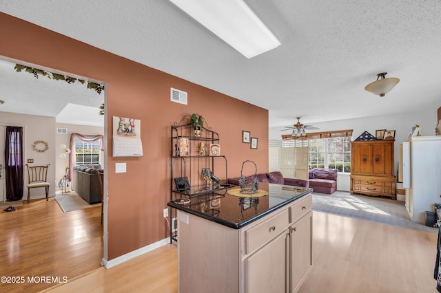 kitchen featuring a healthy amount of sunlight, light wood-style flooring, visible vents, and open floor plan