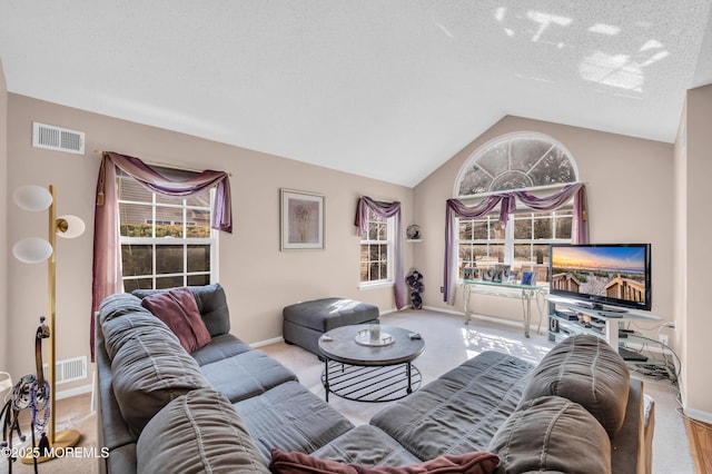 living area with lofted ceiling, carpet flooring, visible vents, and baseboards