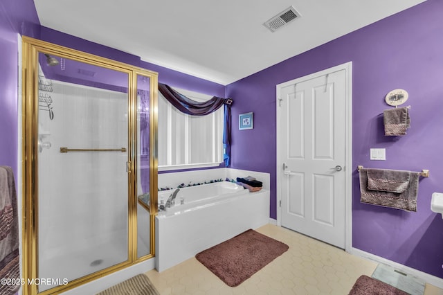 bathroom featuring a bath, a shower stall, visible vents, and baseboards