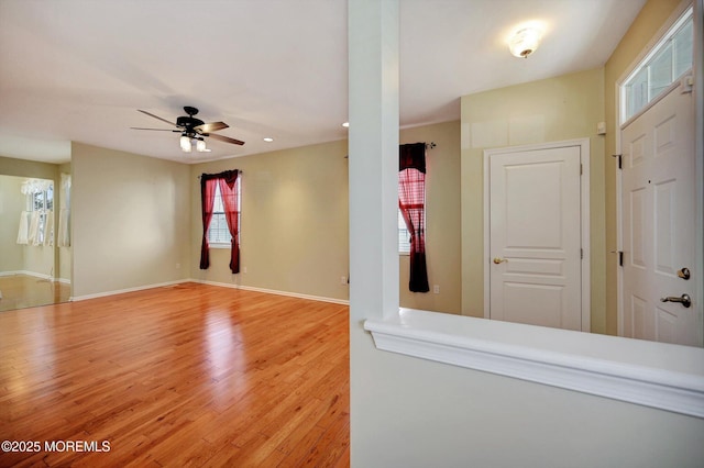 interior space featuring ceiling fan, wood finished floors, and baseboards