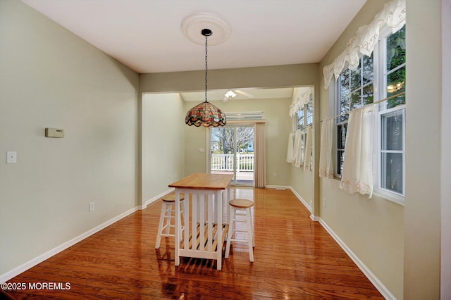 dining space featuring baseboards and wood finished floors