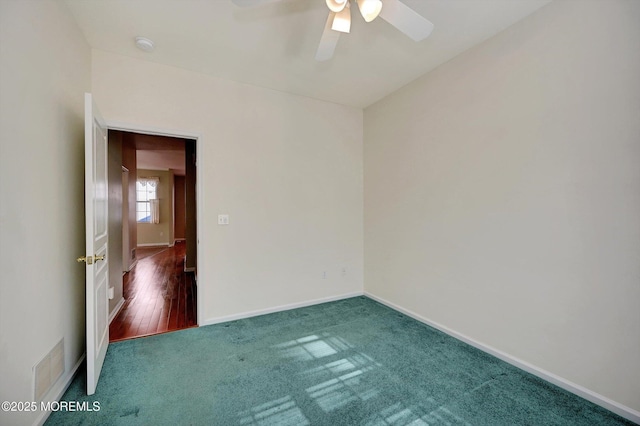 carpeted empty room featuring a ceiling fan, visible vents, and baseboards