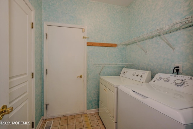 laundry room featuring washer and dryer, laundry area, and wallpapered walls