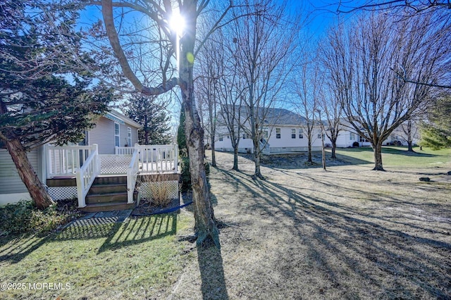 view of yard featuring driveway and a wooden deck