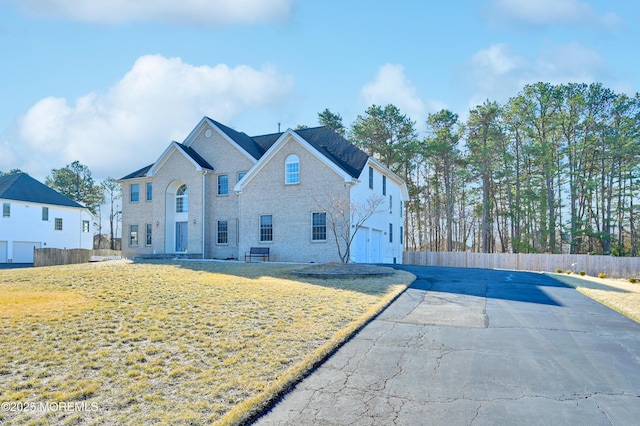 view of front of property featuring a front yard, fence, and driveway