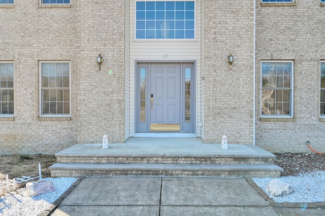 entrance to property featuring brick siding