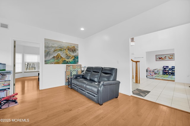 living room featuring recessed lighting, wood finished floors, visible vents, baseboards, and stairway