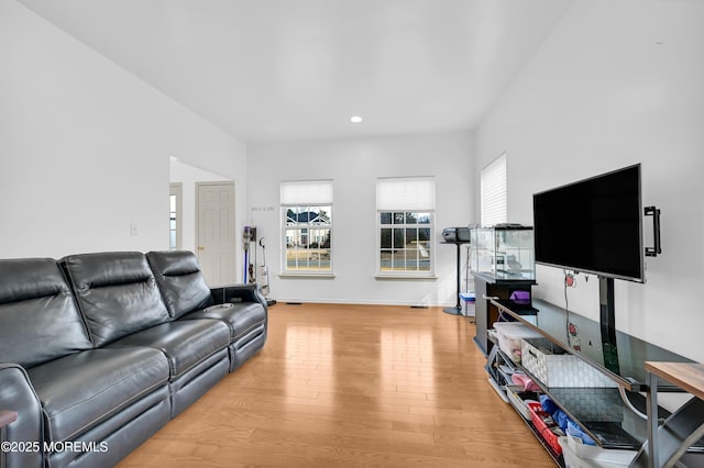 living area featuring light wood-style floors, baseboards, and recessed lighting