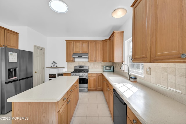 kitchen featuring a sink, stainless steel appliances, light countertops, under cabinet range hood, and backsplash