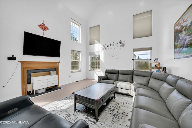 living area featuring high vaulted ceiling, baseboards, and wood finished floors