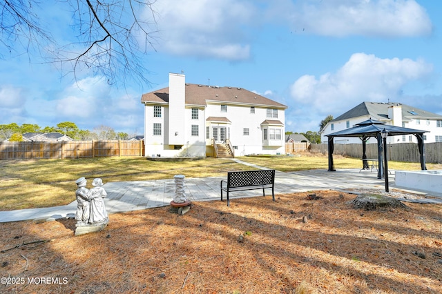 back of house featuring entry steps, a patio, a fenced backyard, a gazebo, and a chimney