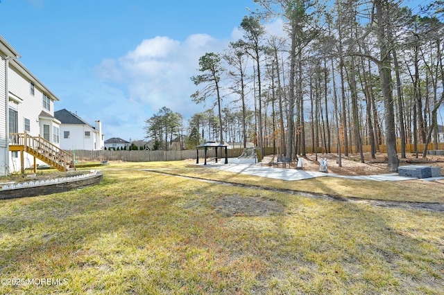 view of yard featuring a patio area, fence, stairway, and a gazebo