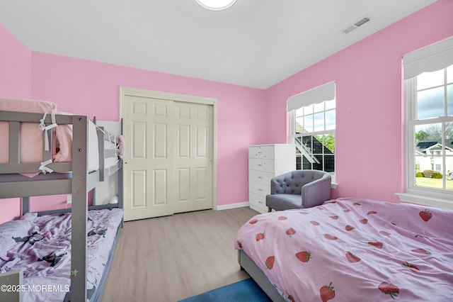 bedroom featuring wood finished floors, visible vents, and baseboards