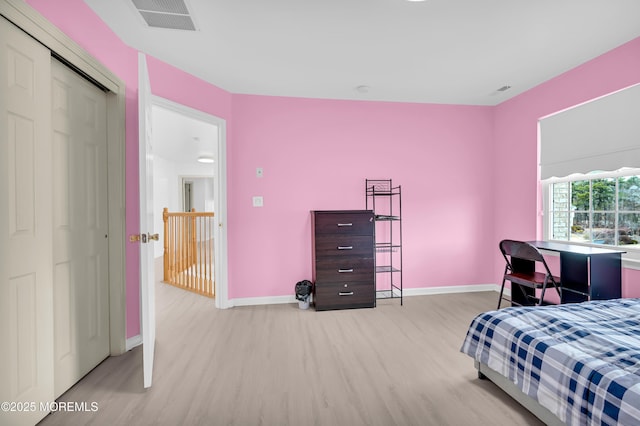 bedroom with wood finished floors, visible vents, and baseboards