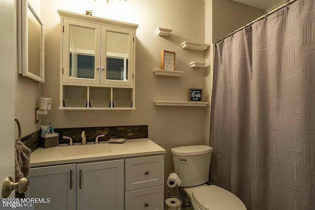 full bathroom featuring curtained shower, vanity, and toilet