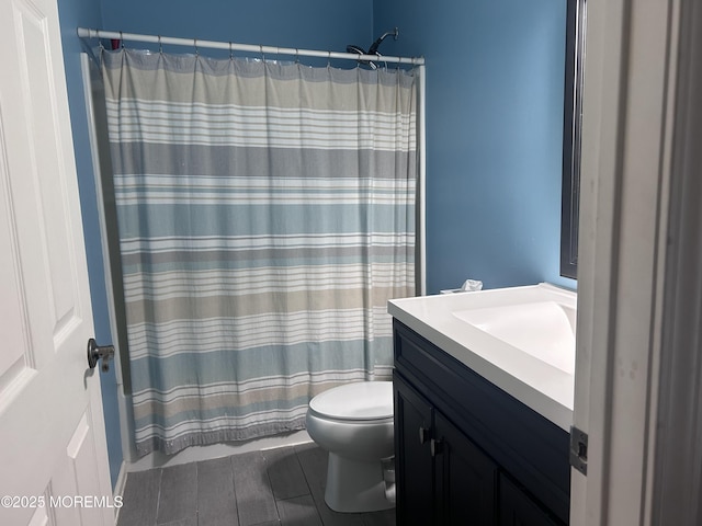 bathroom featuring toilet, curtained shower, and vanity