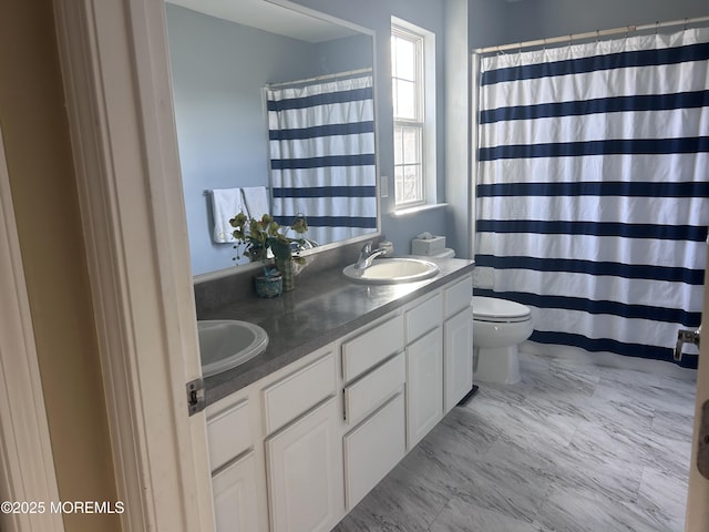 bathroom featuring curtained shower, a sink, toilet, and double vanity