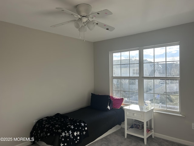 carpeted bedroom with a ceiling fan and baseboards