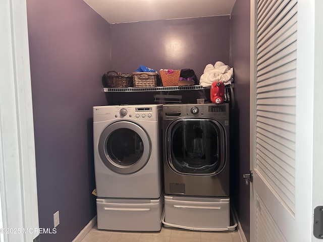 laundry room featuring laundry area, light tile patterned flooring, and washer and clothes dryer