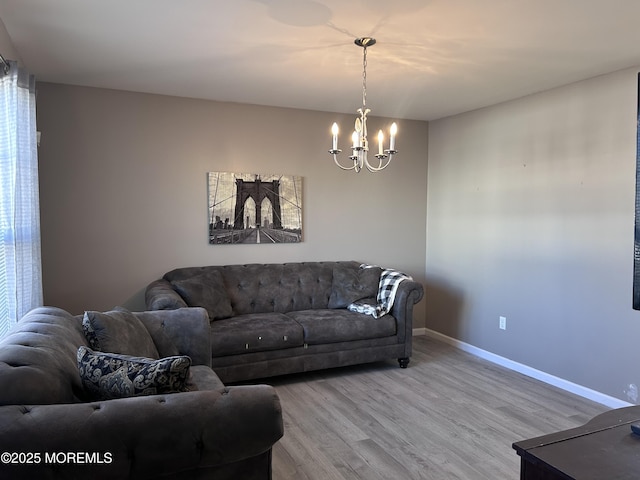 living room with a notable chandelier, baseboards, and wood finished floors