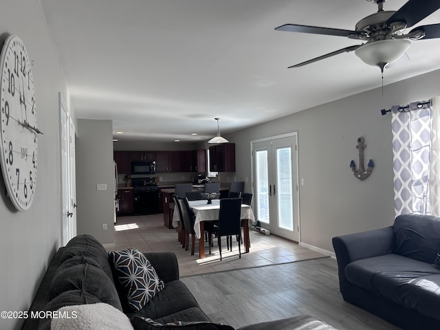 living room with light wood-type flooring, baseboards, and french doors