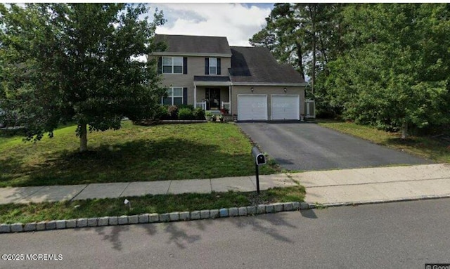 view of front of house featuring aphalt driveway, a garage, and a front lawn