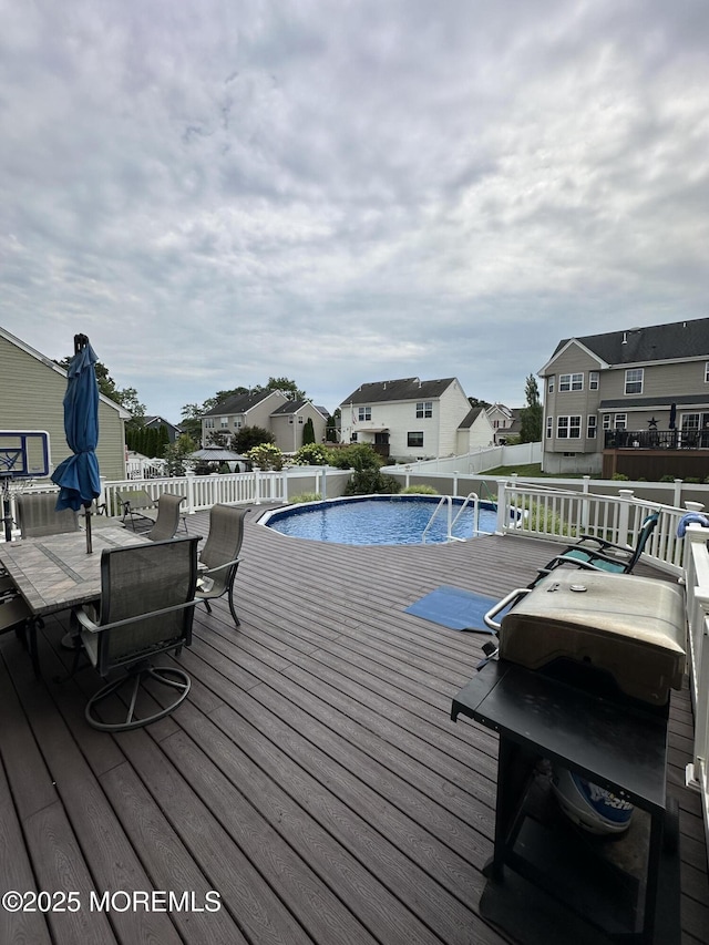 view of pool with a fenced in pool, outdoor dining area, fence, a residential view, and a wooden deck