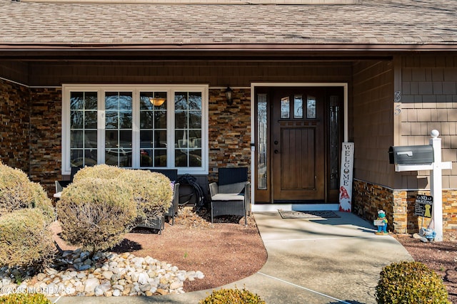 property entrance featuring roof with shingles