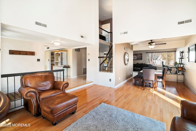 living room with visible vents, wood finished floors, and stairway