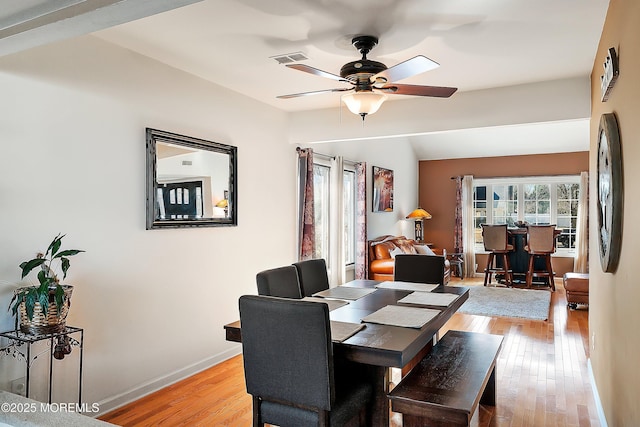 dining space with visible vents, ceiling fan, baseboards, and light wood-style floors