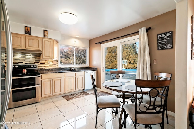 kitchen featuring light brown cabinets, a sink, range with two ovens, decorative backsplash, and dishwasher