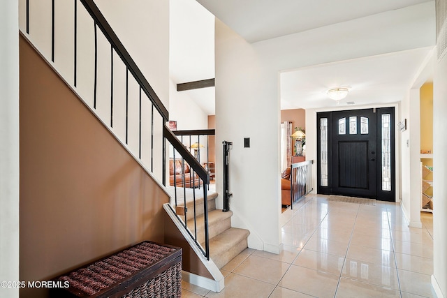 foyer with stairs, light tile patterned floors, and baseboards