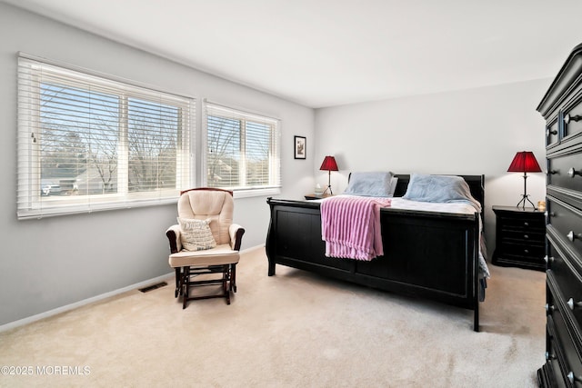 bedroom with baseboards and light carpet