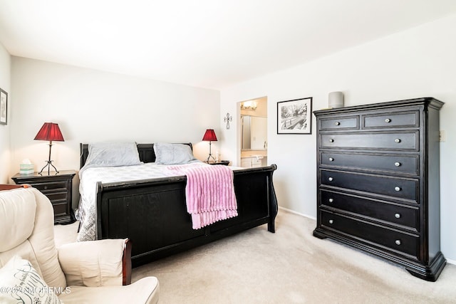 bedroom with ensuite bath, baseboards, and light carpet