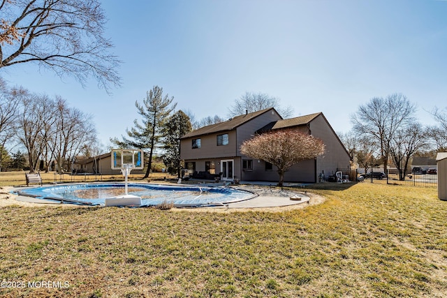 rear view of house featuring a fenced in pool, a lawn, a patio area, and fence