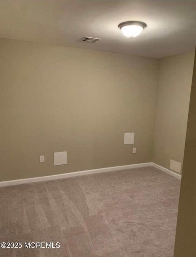 carpeted spare room with visible vents and baseboards