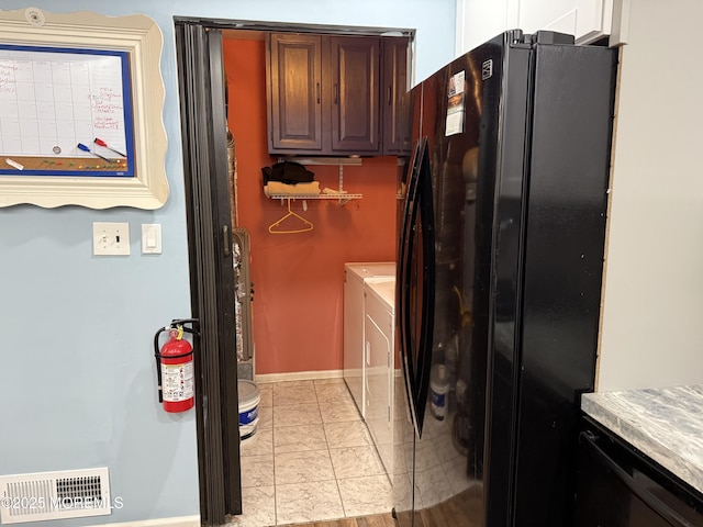 washroom with washing machine and dryer, visible vents, and baseboards