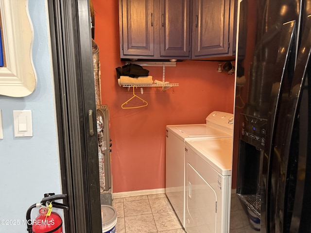 laundry room featuring tile patterned flooring, washing machine and dryer, cabinet space, and baseboards