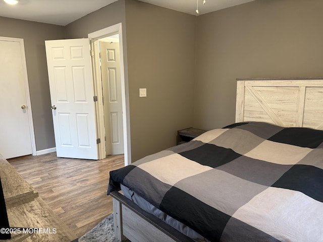 bedroom with baseboards and wood finished floors