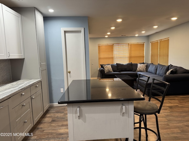 kitchen with a breakfast bar, open floor plan, and dark wood finished floors