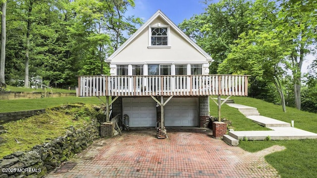 136 Van Brackle Rd, Matawan, NJ 07747 - view of front of house featuring stucco siding, an attached garage, a front lawn, a wooden deck, and driveway