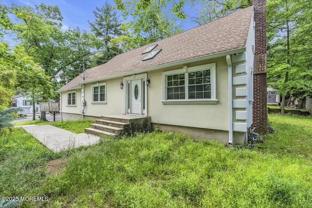 136 Van Brackle Rd, Matawan, NJ 07747 - view of front of property with a shingled roof, a chimney, stucco siding, and a front lawn