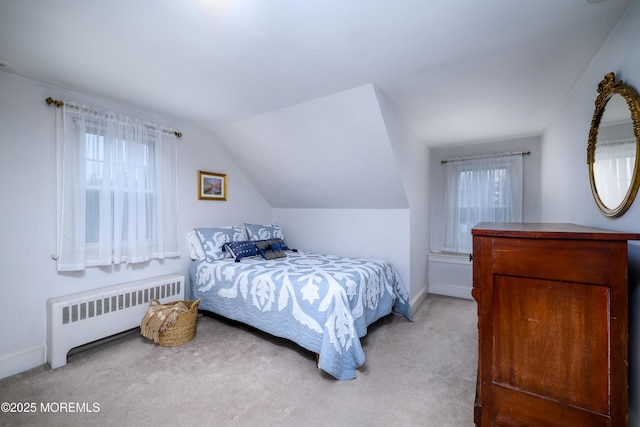 bedroom with vaulted ceiling, radiator heating unit, carpet flooring, and baseboards