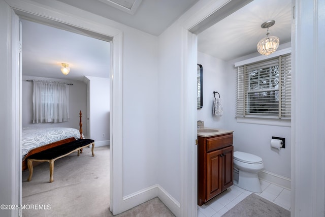 bathroom with toilet, vanity, baseboards, tile patterned floors, and an inviting chandelier