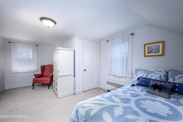 bedroom with light carpet, radiator heating unit, baseboards, and vaulted ceiling