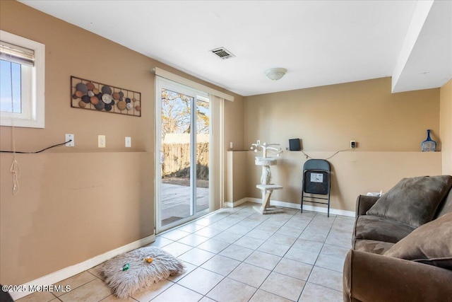 living room featuring light tile patterned floors, baseboards, and visible vents