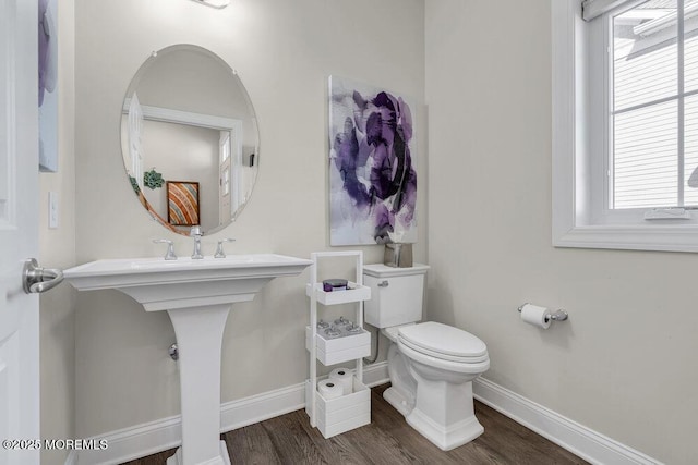 bathroom with wood finished floors, toilet, and baseboards